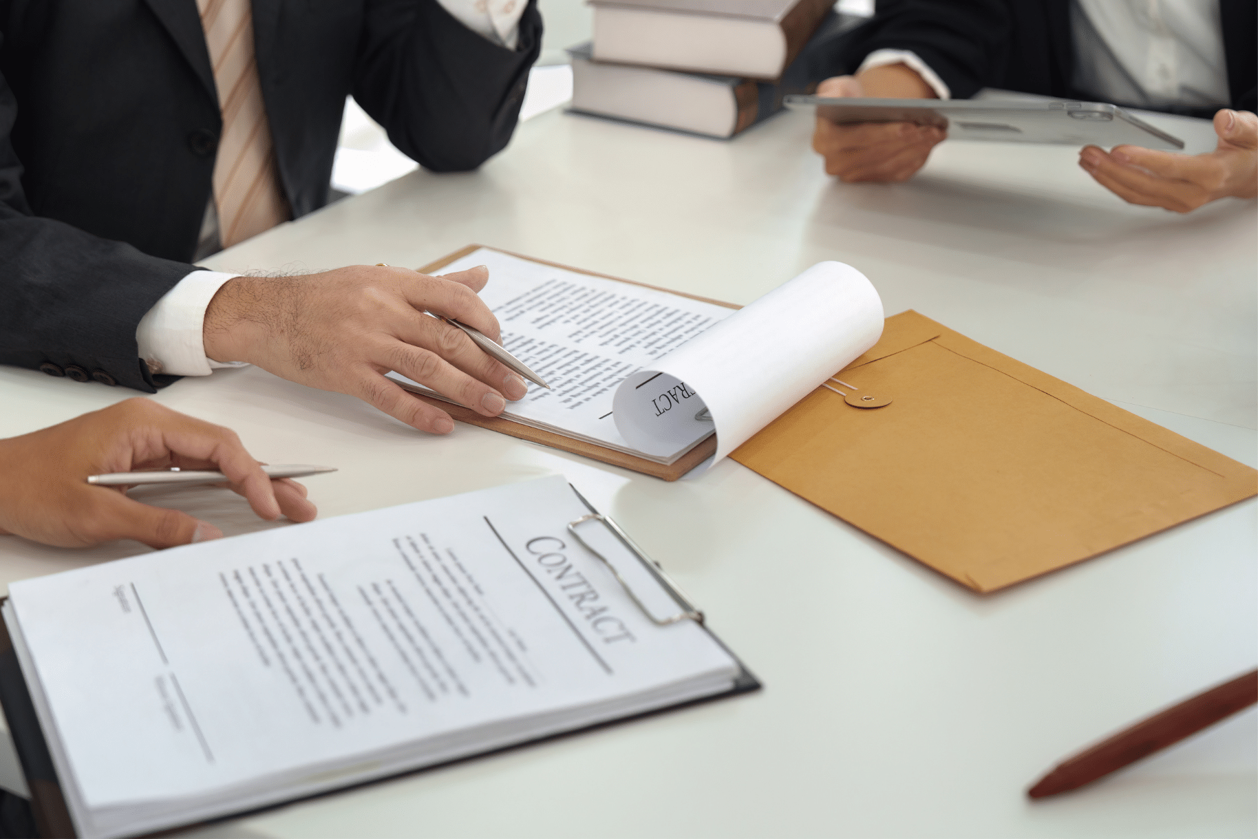 Close-up of hands discussing paperwork and signing a contract during a professional meeting